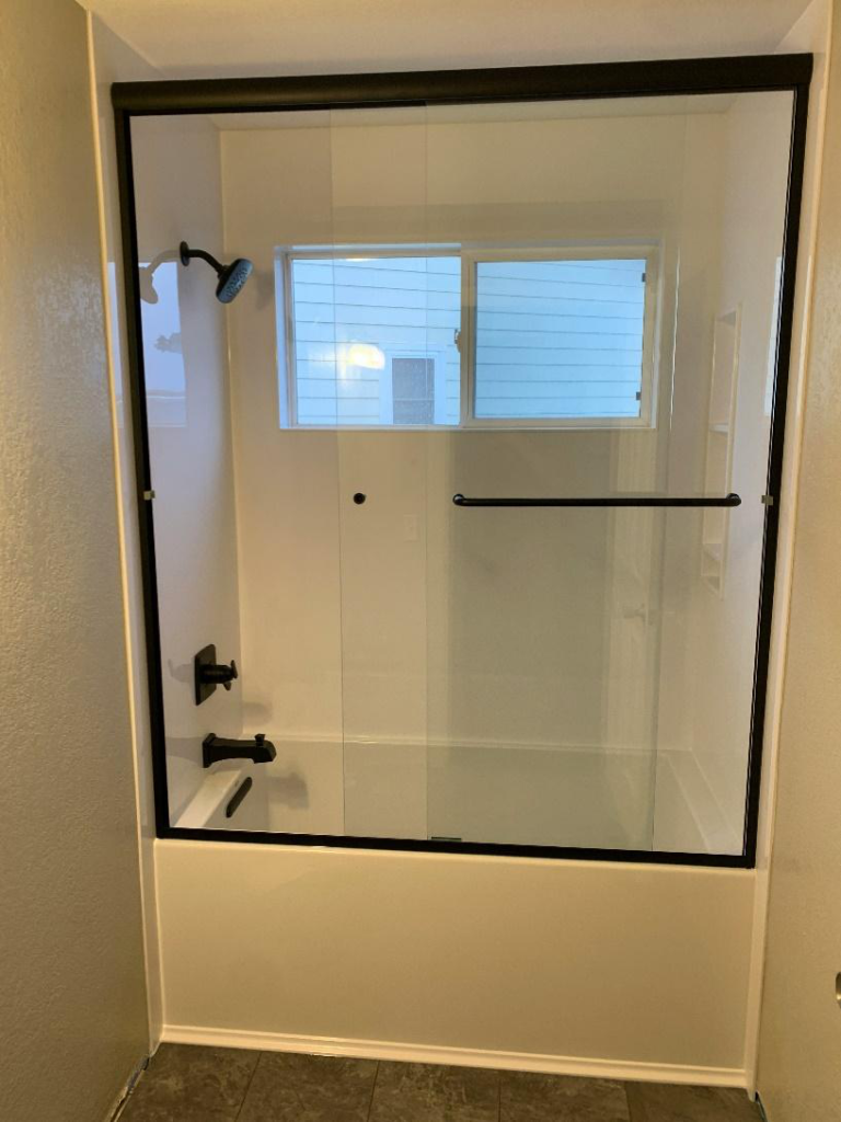 Newly remodeled bathroom in Williamstown with a glass shower enclosure and matte black fixtures.