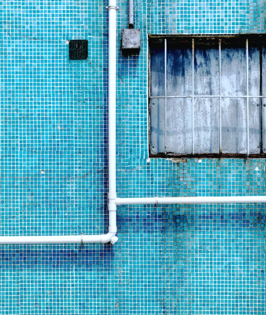 This image shows a blue wall with leak pipes.