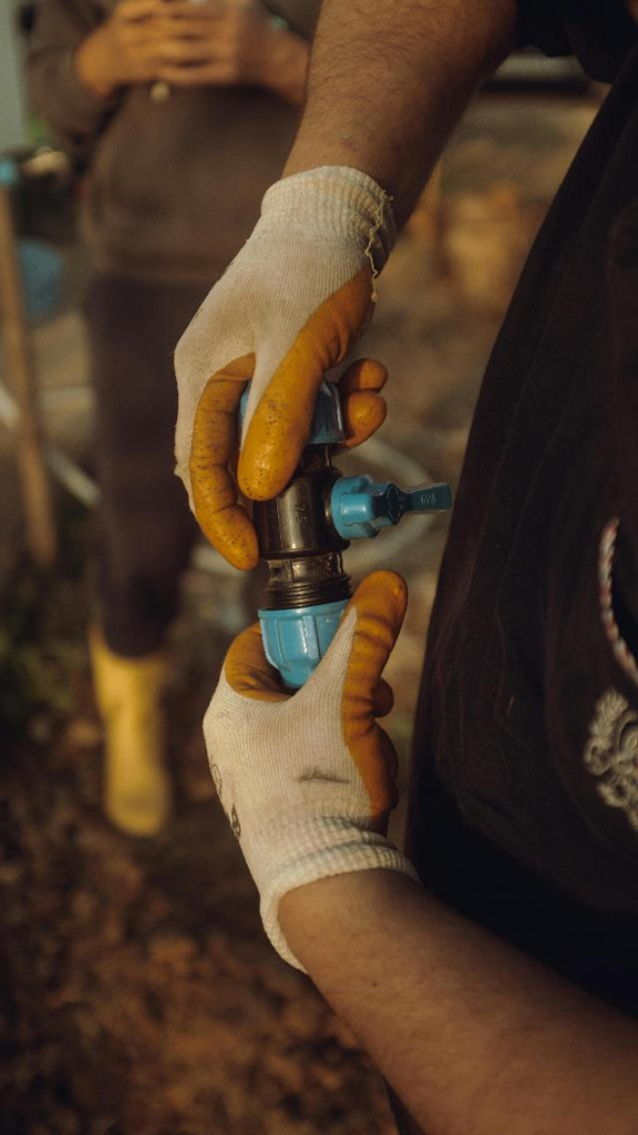 Technician installing or adjusting plumbing valve connection