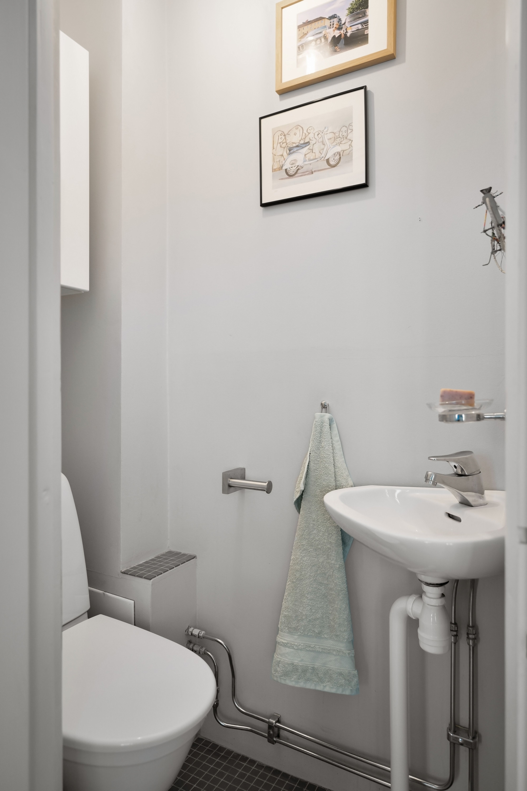 Residential bathroom with a toilet and sink connected to the home drainage system