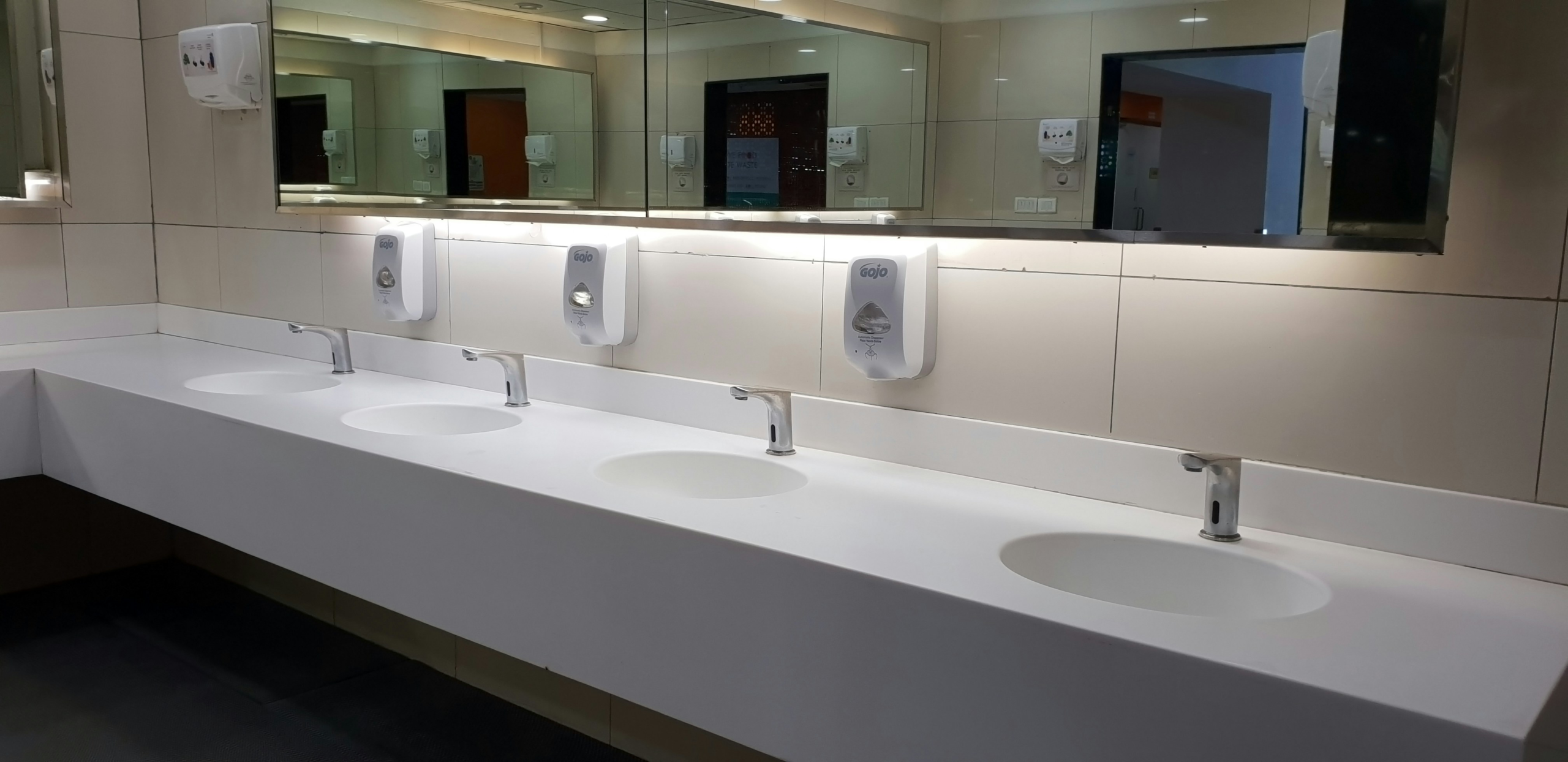 Several sinks installed beside one another in a washroom