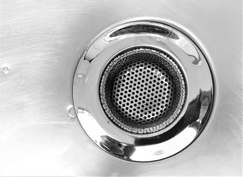 Close-up of a metal drain inside a residential sink
